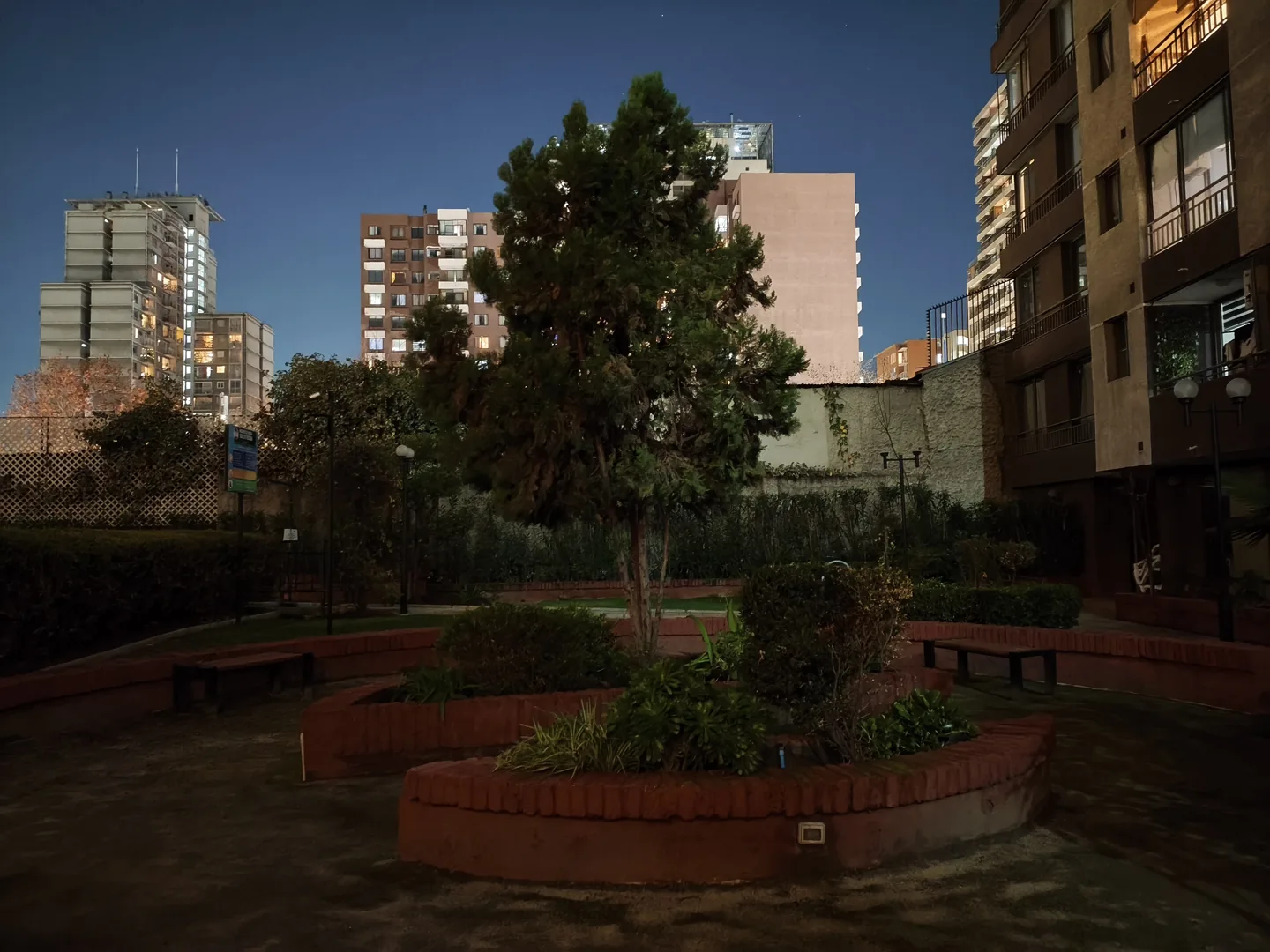 Jardín y edificios de noche fotografiados con la cámara principal del POCO X8 Pro